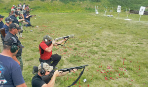 Coaches line up behind their students and critique their abilities of shooting from various kneeling positions.
