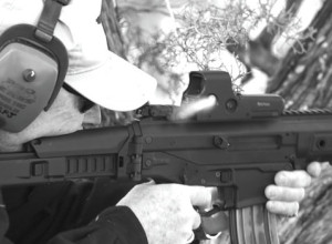 An ejected .223 casing flies past the camera as Johnston engages a far away steel target with the ACR-PDW.  The little carbine hit the farthest target in the center at 240-yards on the third shot by holding on its left edge.