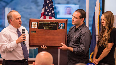 Action Target co-founder Addison Sovine presents the Sgt. Cory Wride Memorial Match plaque to Wride's son.